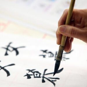 A person is painting chinese characters on paper.